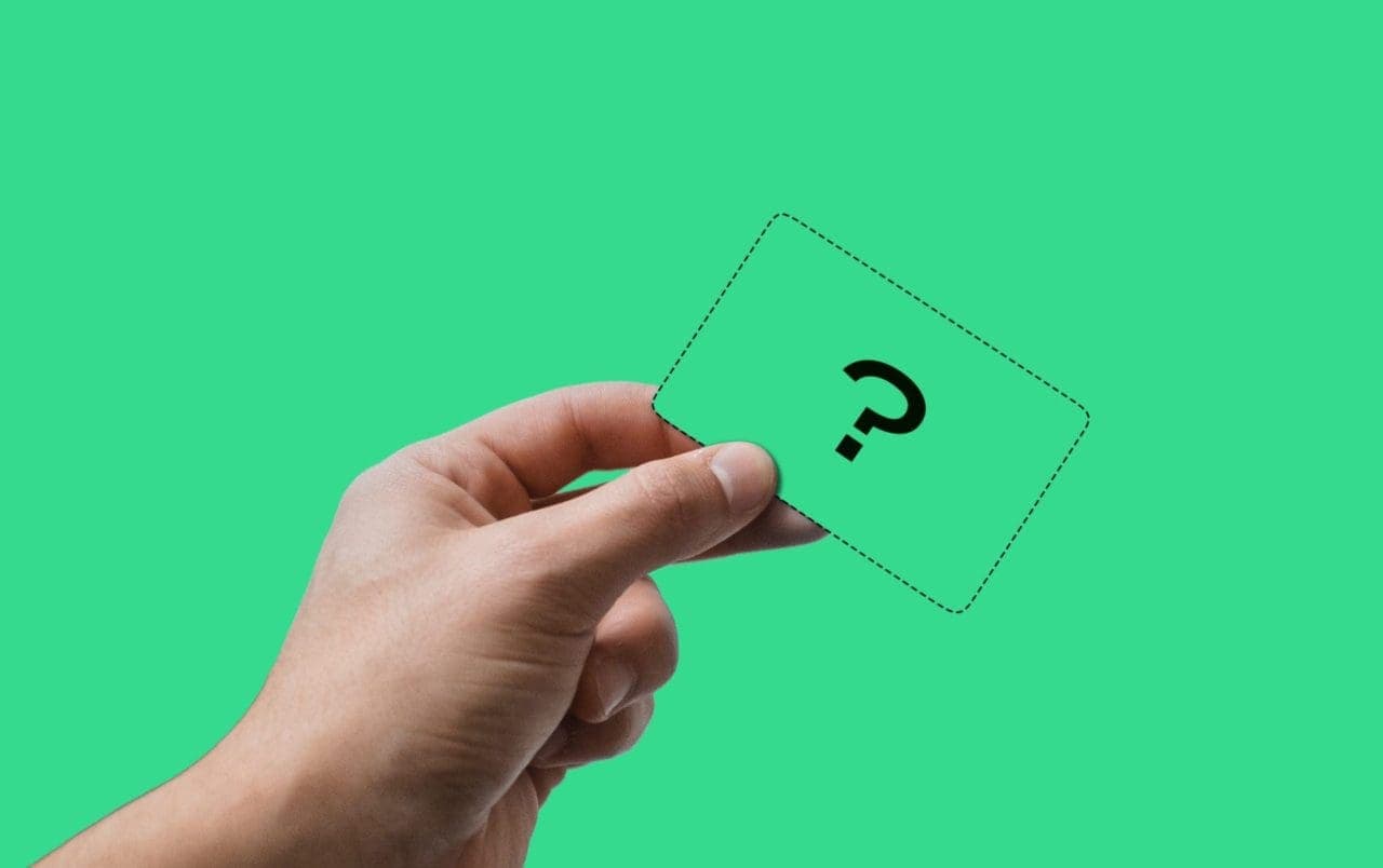 close up hand holding imaginary card with "?" on it