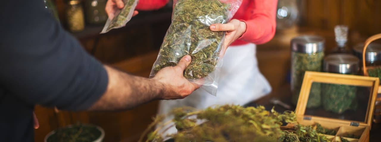 A person paying for cannabis flower at a dispensary